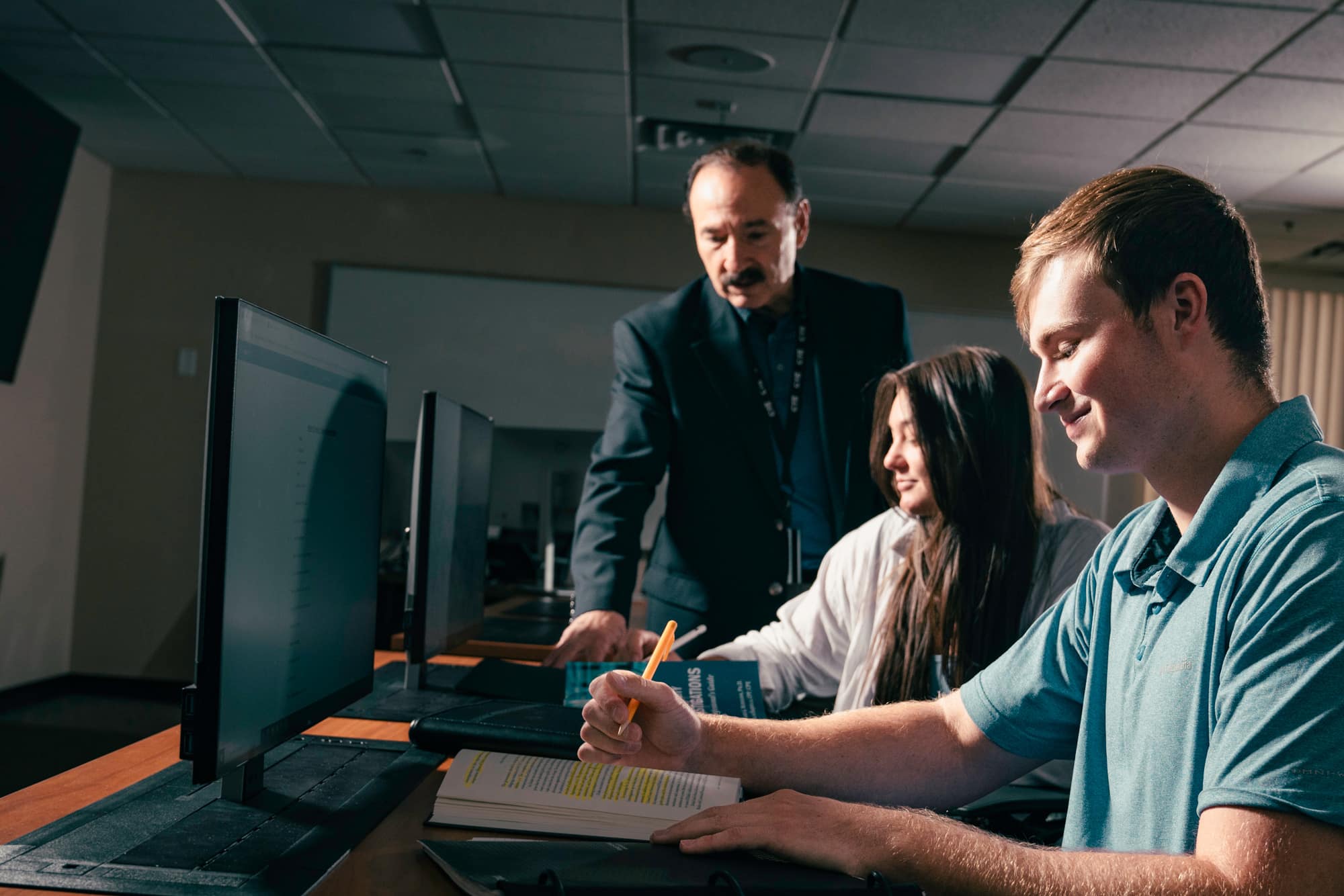Students and faculty member look at a laptop.